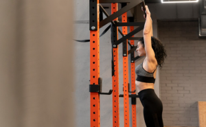 Mulher treinando na barra fixa na parede em uma academia