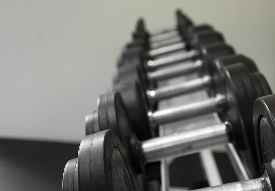 Halteres revestidos com acabamento resistente e pegada confortável, ideais para treinos de força, musculação e exercícios funcionais em academia ou em casa.